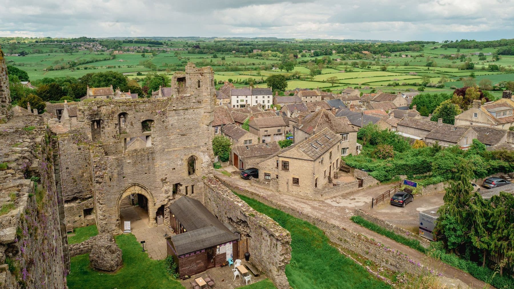 Looking down from Middleham Castle's keep over the gatehouse, stone rooftops and the green patchwork of Wensleydale.