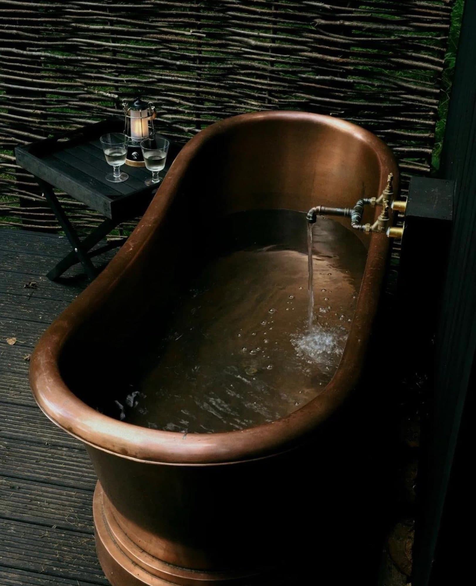 The copper bath on a cabin deck, filling with hot water at dusk